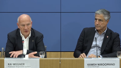 Zu sehen ist ein Ausschnitt einer Pressekonferenz der Senatskanzlei Berlin. Links der regierende Bürgermeister Kai Wegner (CDU), rechts Olympia-Beauftragter Kaweh Niroomand.