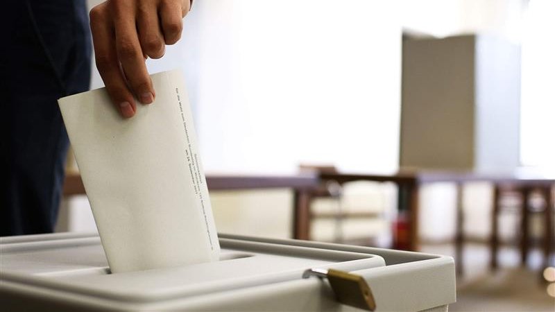 Wahlzettel wird in Urne geworfen