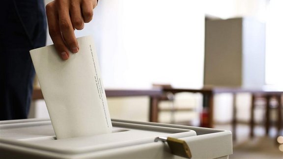 Wahlzettel wird in Urne geworfen