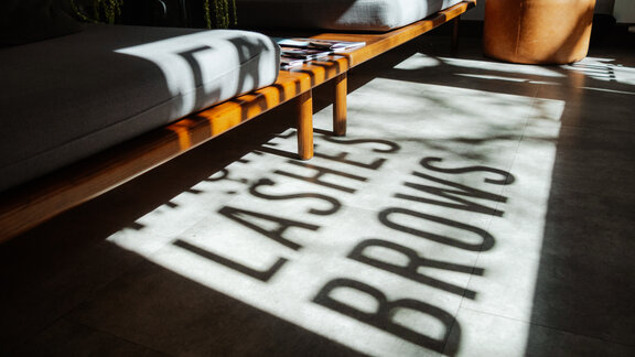 Eine Couch im Wartebereich der Glowy Beauty Bar.