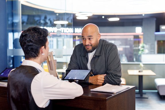 Philip Ibrahim, General Manager des Mercure Hotels Berlin, spricht mit einem Auszubildenden
