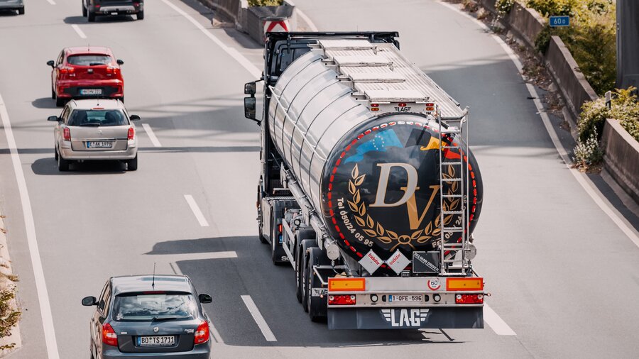 Zu sehen ist eine Autobahn, auf der mehrere Autos und ein LKW fahren.