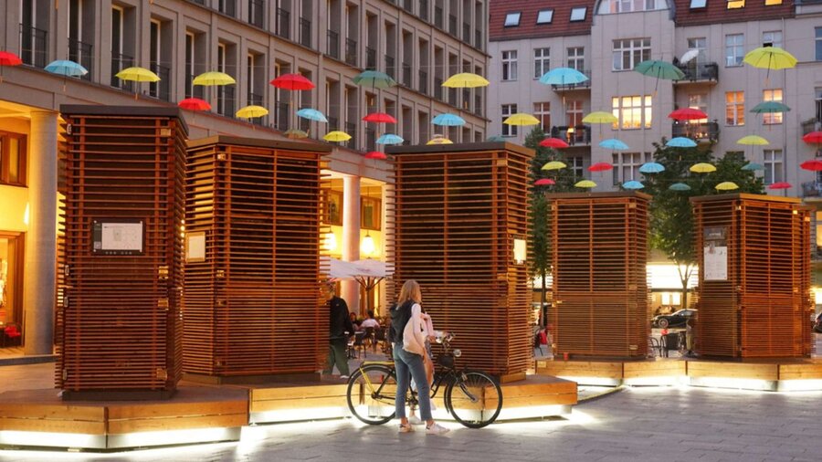 Fünf Moosmodule stehen auf einem Platz in der Innenstadt. 