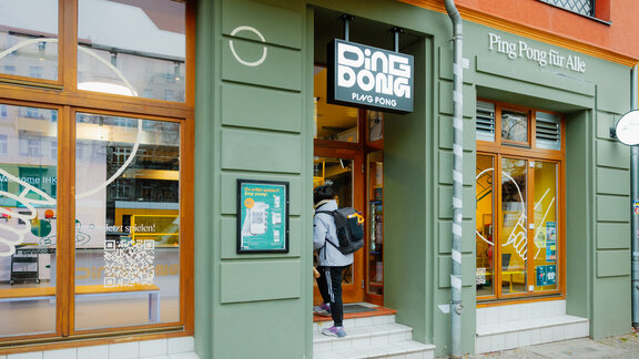 Eine Person geht in den Laden von Ding Dong Ping Pong hinein.