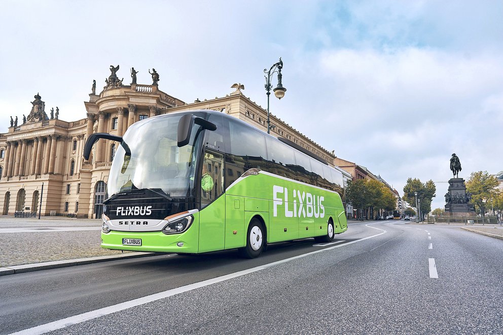 Grüner FlixBus-Reisebus der Marke Setra auf einer Straße in Berlin vor historischen Gebäuden