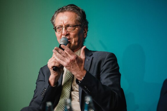 Ein Mann spricht in ein Mikrofon.