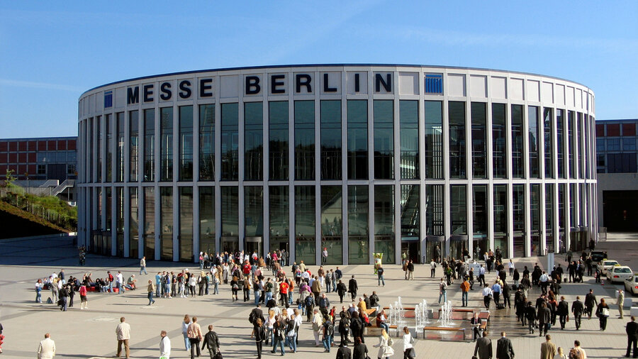 Zu sehen ist das Gebäude der Messe Berlin mit Besuchern im Vordergrund