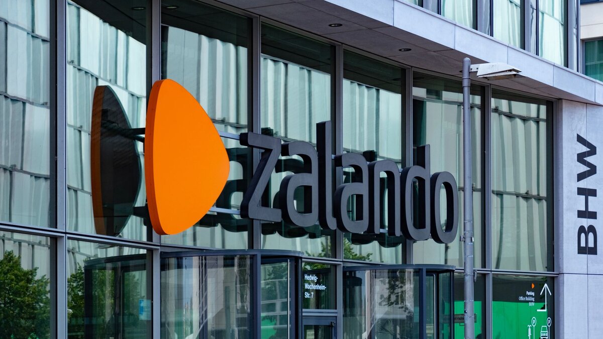Zu sehen ist die Glasfassade eines Bürogebäudes. Über dem Eingang steht der Schriftzug "Zalando". Es handelt sich um die Zentrale des Modehändlers in Berlin.
