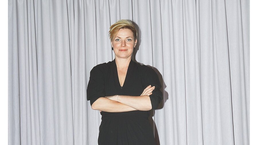 Eine weiße, blonde Frau im schwarzen Kleid