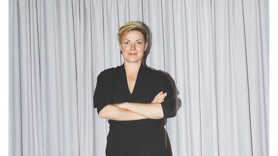 Eine weiße, blonde Frau im schwarzen Kleid