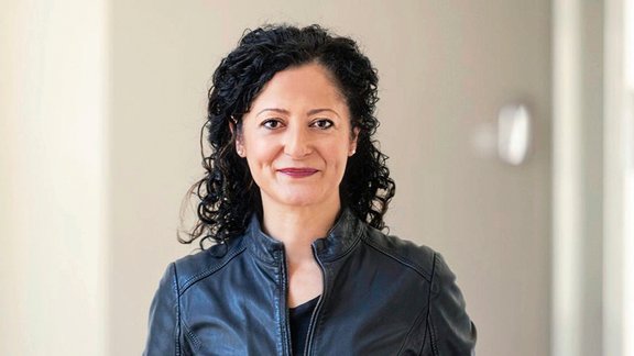 Auf dem Bild ist eine Frau mit dunklen Haaren zu sehen.