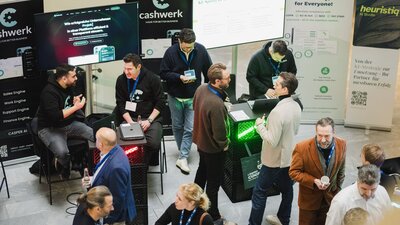 Zu sehen sind mehrere Menschen von oben, die sich auf einer Veranstaltung befinden und sich unterhalten. Es handelt sich um die DIGITAL+ Konferenz der IHK Berlin und HTW Berlin.