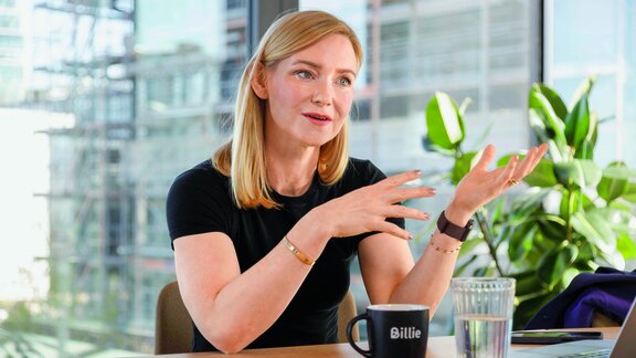 Aiga Senftleben sitzt an einem Büroschreibtisch und schaut in Richtung Interviewparter