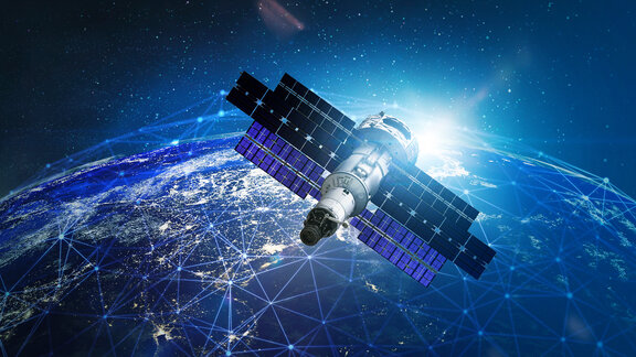 Satellit mit ausgebreiteten Solarpaneelen über der Erde, die von einem Netzwerk aus Lichtlinien umgeben ist.