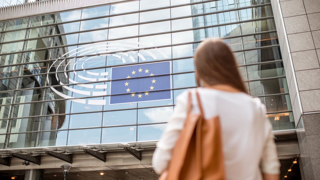 Eine Frau steht vor dem Europaparlament in Brüssel.