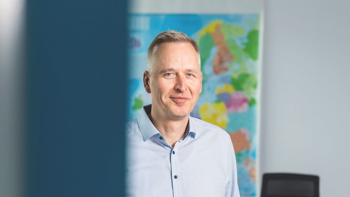 Auf dem Bild ist ein weißer Mann mit blauem Hemd und Jeanshose zu sehen.