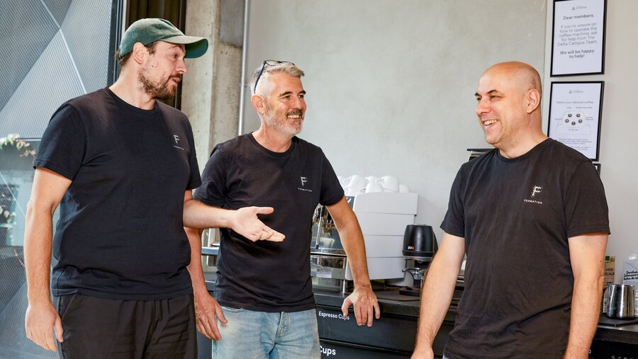 Jacob Otto, Ian Hannigan und Jilles van Gurp in einer Kaffeeküche.